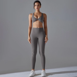 Two-piece charcoal grey yoga set featuring high waist leggings and a twist front sports bra