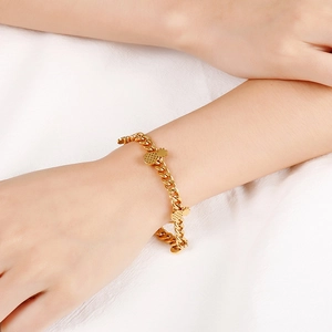 Fashionable gold-plated stainless steel pineapple charm bracelet on a model's wrist