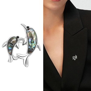 Abalone shell double dolphin brooch in silver finish with model wearing shot for scale