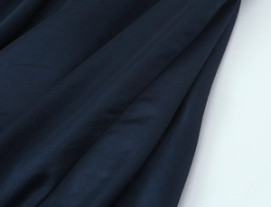 Detaillierte Nahaufnahme der marineblauen Satinstruktur mit weichen diagonalen Falten