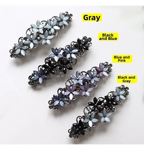 Detail of four vintage floral alloy hair clips with rhinestones in multiple colors