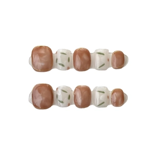 Handmade press-on nails with amber marble texture and green leaf patterns on white background