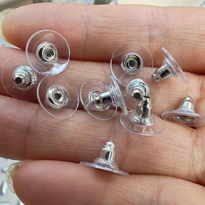 Macro di chiusure per orecchini in plastica trasparente e metallo argentato sulla mano