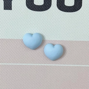 Gros plan de breloques cœur en résine bleu clair mat pour bijoux DIY et nail art