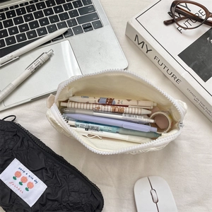 Close-up of large capacity pencil cases featuring unique bubble textured fabric and embroidery