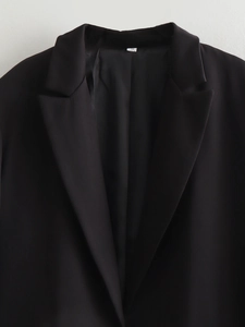 Detail of black blazer lapel and stitching with S size label on minimalist background