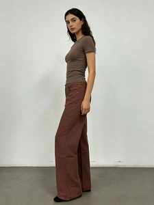 Vista laterale dei pantaloni marroni a vita alta a gamba larga con top corto coordinato