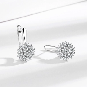 Elegant silver flower earrings with pavé zircons shown on a white minimalist background