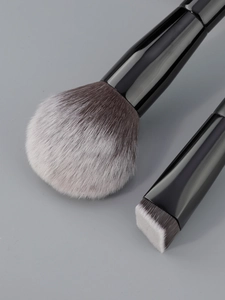 Détail macro de pinceaux de maquillage aux fibres synthétiques souples et manches noirs brillants