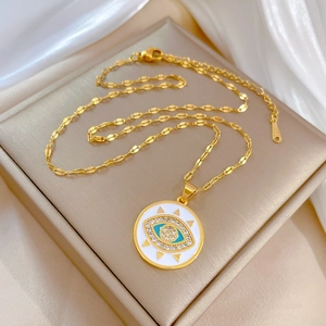 Golden titanium steel evil eye necklace with blue crystals on a beige display box