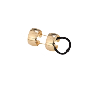 Elegant gold metal ponytail holder with striped texture and black elastic tie on white background