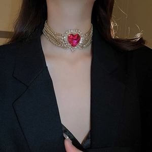 Detail of multi-row gold choker with large pink heart gemstone and sparkling rhinestones