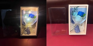 Detail of blue soap rose bouquet in transparent box with warm LED lighting effect