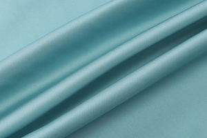 Detailansicht des glatten petrolfarbenen Satinstoffs mit luxuriöser Textur und Glanz