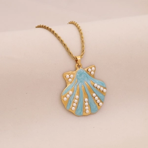 Golden necklace with shell pendant featuring light blue enamel and white pearls on beige base