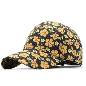 Detail of floral baseball cap featuring yellow hibiscus print on black twill fabric