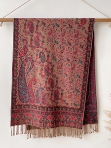 Detail of red paisley cashmere-feel scarf with intricate patterns and elegant fringe trim