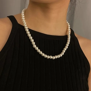 Close-up of elegant cream white pearl necklace on model neck with soft lighting