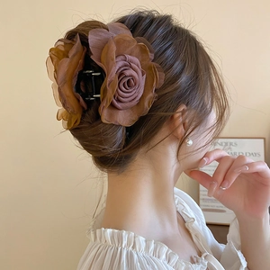 Detailansicht einer karamellfarbenen Rosen-Haarklammer in einer eleganten Hochsteckfrisur