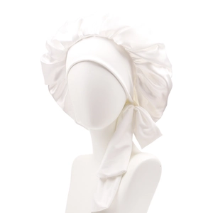 Detail of white satin sleep bonnet with wide elastic headband and side ribbon tie