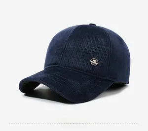 Detail view of navy blue corduroy baseball cap with metallic logo and textured fabric