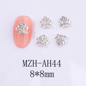 Détail du bijou d'ongle couronne argentée 8x8mm avec strass sur des ongles roses