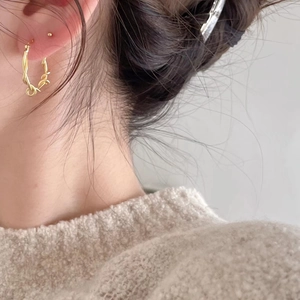 Minimalist twisted woven gold hoop earrings shown on model for stylish everyday wear