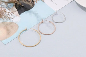 Detail von großen Creolen-Sets in Gold, Roségold und Silber mit feiner Streifentextur