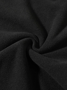 Detailed macro texture of soft black coral fleece fabric showing thick velvet fiber quality