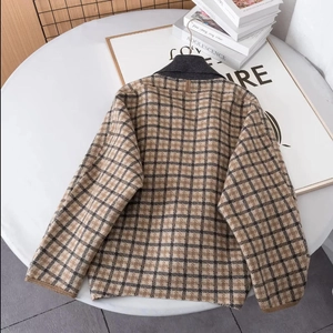 Ensemble cardigan en tricot à carreaux beige et marron sur table blanche