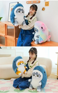 Detail of shark cat plush toys showing blue and rainbow shark costumes on soft stuffed cats