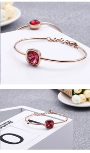 Dettaglio del bracciale geometrico in oro rosa con cristallo rosa quadrato e catena estesa