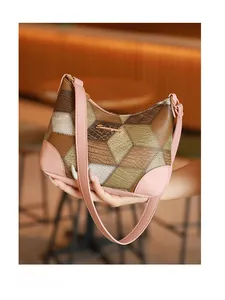 Close-up of retro geometric patchwork underarm bag with pink strap in a cafe setting