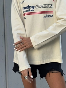 Λεπτομέρεια βαμβακερού μακρυμάνικου T-shirt με τύπωμα κειμένου και υφή του υφάσματος