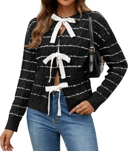 Detail of cable knit cardigan featuring black stripes and decorative white bows