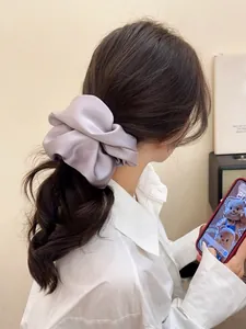 Detailed view of an oversized lavender satin scrunchie styled on a ponytail hairstyle