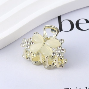 Macro shot of gold butterfly hair claw with rhinestones and white cat eye stones