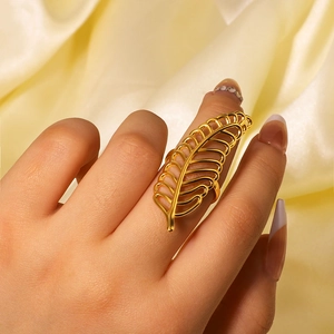 Elegant gold hollow feather stainless steel ring worn on hand with satin background