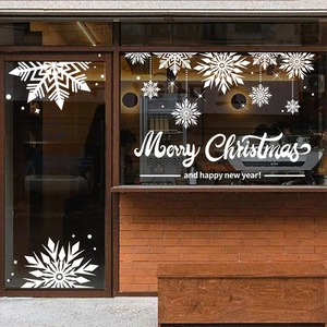 White snowflake window decals with Merry Christmas text on a glass shop storefront