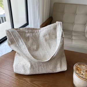 Dettaglio della borsa tote in tela bianco sporco con puntini colorati e logo Simple Wish