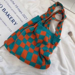 Detailed close-up of the knitted orange and blue checkerboard tote bag with tight texture