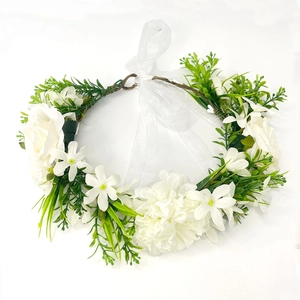 Detail of sunflower headpiece with white silk flowers and green leaves on white background