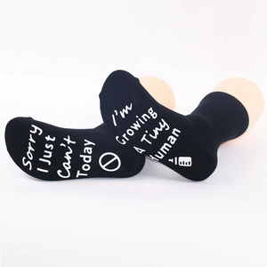 Detail of black non-slip socks with white Sorry I Just Can't Today text on soles