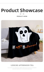 Dettaglio di una coperta di Halloween in flanella nera con fantasma adagiata su un divano