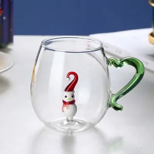 Macro detail of heat-resistant glass mug with green wavy handle and 3D snowman inside