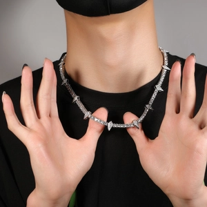 Hip hop silver thorn necklace with clear zircons worn by model on grey background