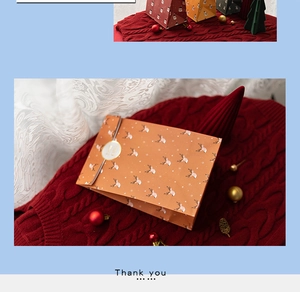 Close-up of brown paper Christmas gift bag with reindeer pattern on red knit background