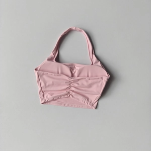 Detail of pink halter sports bra with ruched chest design and high elasticity fabric