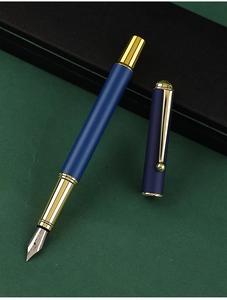 Close-up of matte blue fountain pen with gold clip on dark green leather background