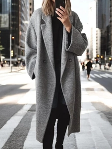 Détail d'un long manteau en laine gris avec double boutonnage au style urbain décontracté
